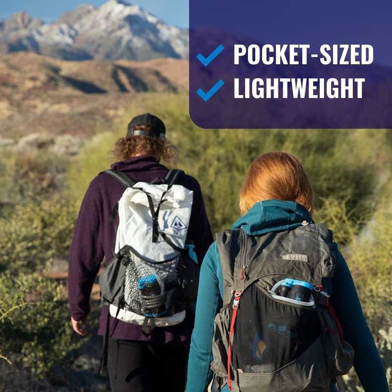 Load image into Gallery viewer, Hikers walking towards a mountain with LifeSaver Wayfarer water filters in their backpacks