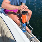 Man using an orange LifeSaver Liberty to fill a water bottle from a lake